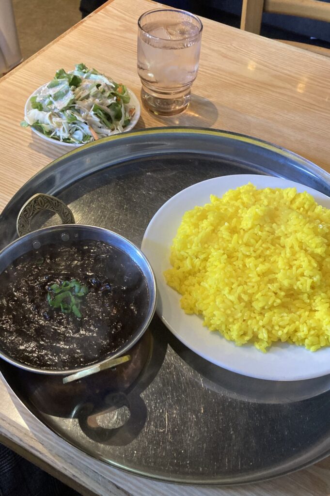 カレー１種のランチセット。漆黒のブラックキーマカレーと、黄色いライスのコントラストが印象的な一皿